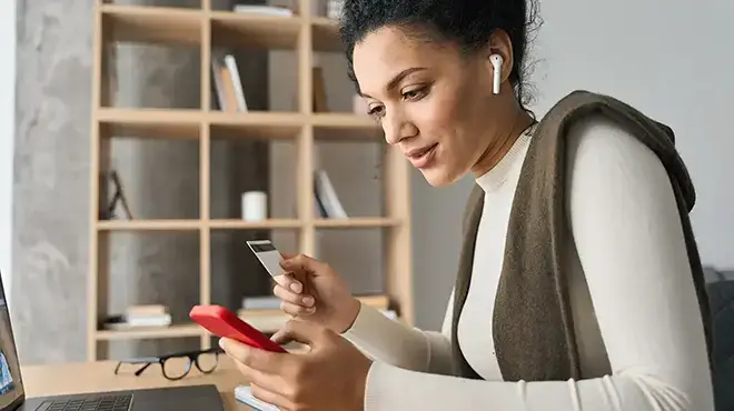 woman on phone holding credit card